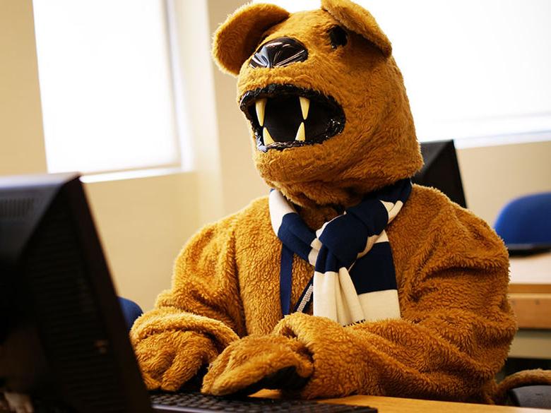 尼塔尼狮子吉祥物在教室里的电脑上查找信息